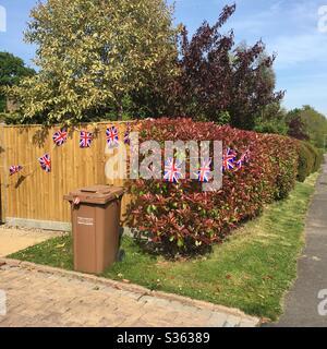 Ve Day il giorno bin - Ve Day celebrazioni con una siepe e recinzione decorata con Union Jack bunting bandiera Foto Stock