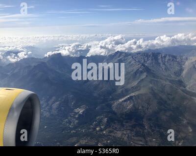 Vista dall'aereo delle montagne in Corsica. Piano motore giallo in primo piano Foto Stock