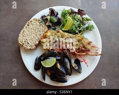 Thermidor di aragosta con cozze, pane soda e insalata Foto Stock