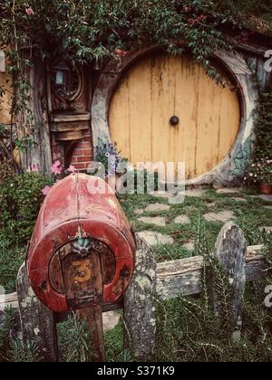 Hobbiton. Luogo bucolico in Nuova Zelanda dove vivono gli hobbit della Terra di mezzo. Set di film Lord of the Rings. Sportello giallo e casella postale rossa Foto Stock