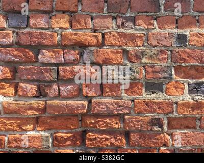 Uno sfondo rosso mattone usurato e intemperato con spazio di copia Foto Stock