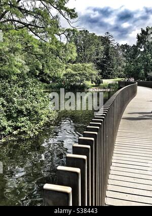 Sackler Crossing, un ponte in granito nero / passerella sul lago presso i Royal Botanic Kew Gardens Foto Stock