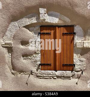 Moderna persiane finestra in antico muro casa irregolare - Bélâbre, Indre, Francia. Foto Stock