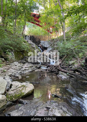 Ponte rosso su Foundry Brook e cascata West Point Foundry Preserve Cold Spring New York. Splendido paesaggio estivo. Foto Stock
