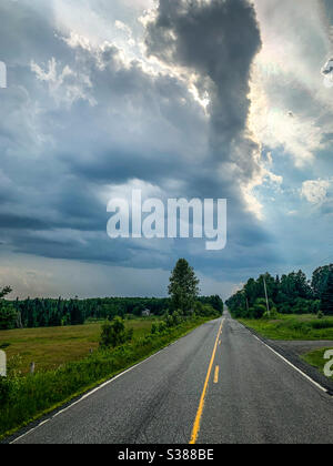 Un cielo spettacolare su una strada di campagna in un pomeriggio estivo Foto Stock