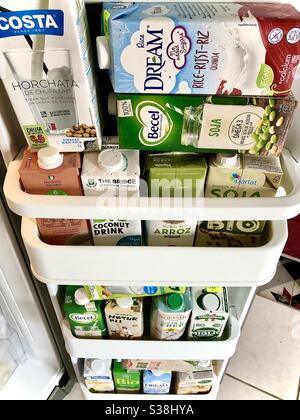 Porta del frigorifero piena di cartoni di prodotti lattiero-caseari a base di piante alternative. Foto Stock