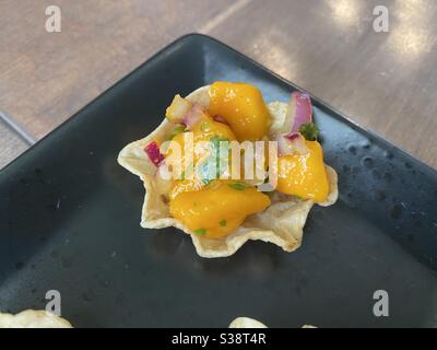 Salsa di mango servita con patatine di tortilla Foto Stock