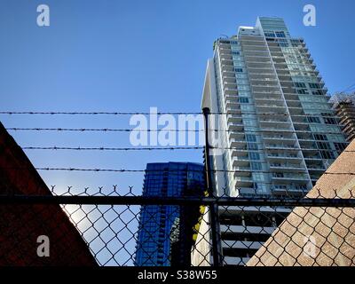 LOS ANGELES, CA, GIU 2020: Nuovi appartamenti ed edifici commerciali visti attraverso recinzione sagome e filo spinato in primo piano Foto Stock