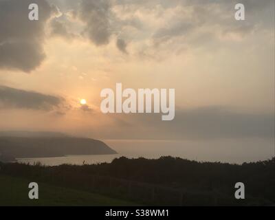 Nebbia sulla baia di Cardigan in una soleggiata serata di agosto. La vista è da Tresaith che guarda verso Aberporth. Foto Stock