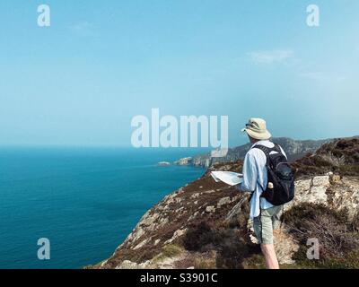 Walker, escursionista, sulla strada costiera tra South Stack e North Stack a Gogarth Bay, Holyhead, Anglesey, Galles del Nord Foto Stock