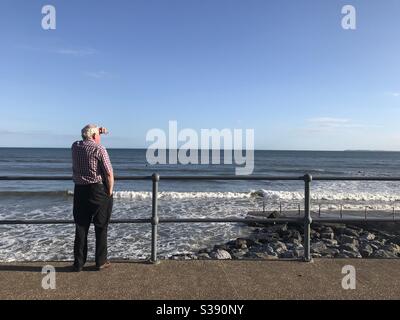 Uomo che guarda il mare a Pendine, Carmarthensshire, Galles. 13 luglio 2020. Foto Stock