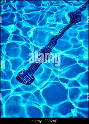 Piccole piastrelle unite insieme in fondo ad una piscina aiutano a indicare una corsia per nuotare. Sole significa acqua frizzante. Aggiornamento. Foto ©️ COLIN HOSKINS. Foto Stock