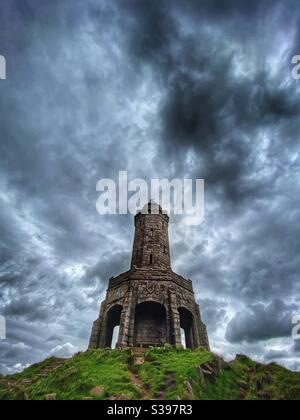 Jubilee Tower (The Rocket) Su Darwen Moor da basso angolo contro un cielo drammatico Sopra Blackburn in Lancashire Foto Stock