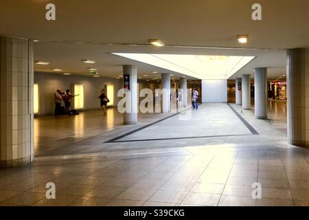 Passeggeri a piedi e musicisti di strada nel sottopassaggio di Keleti palyaudvar (stazione ferroviaria di Keleti), Budapest, Ungheria Foto Stock