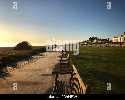 Panchine in fila lungo il lungomare accanto alla spiaggia Al mare affare Kent UK Foto Stock