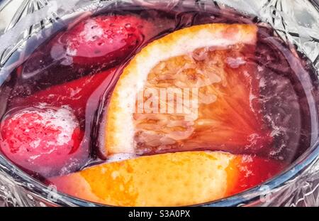 Fragole e fette di arancia in un bicchiere di sangria Foto Stock