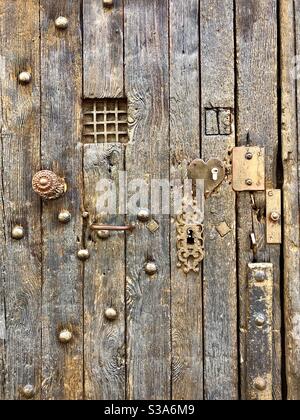 Vecchia porta medievale in quercia con borchie in ferro, maniglie, ferri e riparazioni - Tours, Indre-et-Loire, Francia. Foto Stock