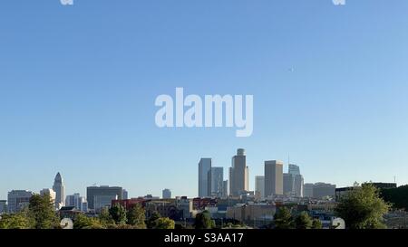 LOS ANGELES, CA, LUGLIO 2020: Skyline del centro con grattacieli nel quartiere finanziario sulla destra e Municipio sulla sinistra. Aereo che vola attraverso cielo blu in alto Foto Stock
