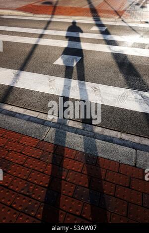 uomo ombra sul crosswalk Foto Stock