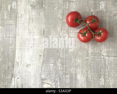 Un mazzetto di grandi pomodori sulla vite Foto Stock