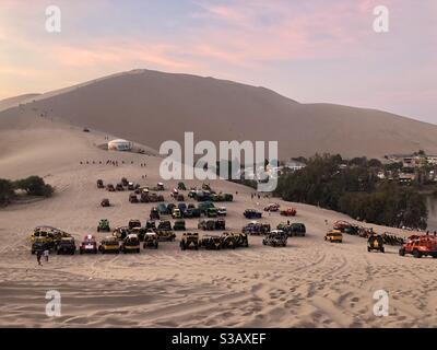 I buggy si allineano su una duna di sabbia in attesa di Huacachina i turisti Foto Stock