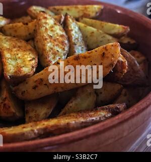 Primo piano di ciotola di spicchi di patate Foto Stock