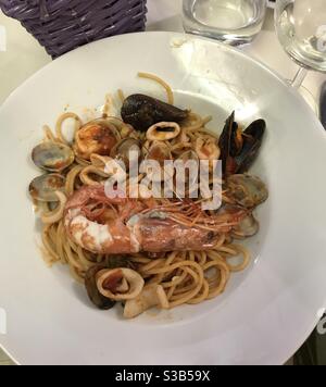 Un piatto tradizionale di pasta di pesce ‘spaghetti allo scoglio’ In un ristorante italiano Foto Stock