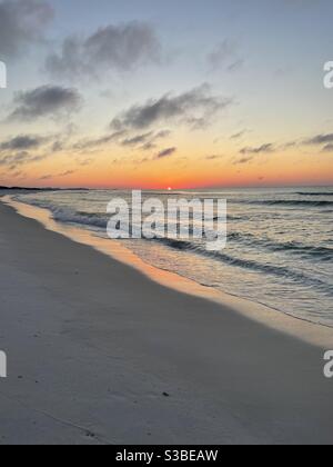Sole che sorge basso all'orizzonte sopra l'acqua smeraldo Del Golfo del Messico Florida Foto Stock
