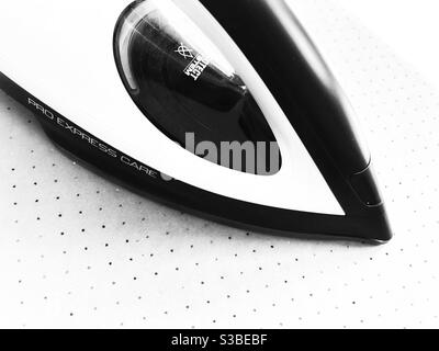Ferro da stiro a vapore grafico, bianco e nero ad alto contrasto, dall'alto su uno sfondo molto chiaro. Foto Stock