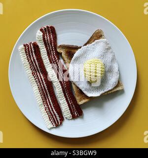 Pancetta a maglia e uovo fritto lavorato a maglia su toast. Foto Stock