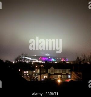 Lo stadio di calcio Tottenham Hotspur si è illuminato in una notte di inverni il giorno della partita, visto dalle strade circostanti Foto Stock