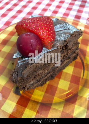 Fetta di torta al cioccolato con ciliegia rossa e fragola Foto Stock