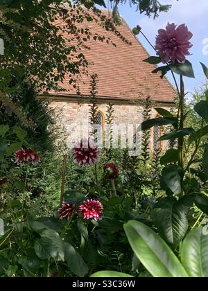 Inglese cottage giardino con chiesa gotica vittoriana a metà estate Foto Stock