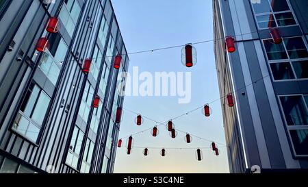 Le lanterne rosse si sono incastrate tra gli edifici moderni di China Town, Los Angeles, guardando in alto nel cielo a un'ora magica Foto Stock