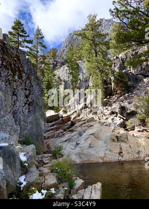 Escursione sul lago Eagle dietro il lago Tahoe vicino a Georgetown in California USA. Gli alberi Evergreen che crescono da scogliere rocciose con neve cristallina si fondono e piscine in una vacanza a piedi brillante e croccante a settembre Foto Stock