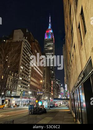 Una movimentata 34° strada vicino a Park Avenue alla vigilia di Capodanno con le luci colorate dell'Empire state Building scintillanti sullo sfondo a New York City, Stati Uniti Foto Stock