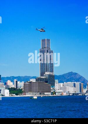 Un elicottero che sorvola il porto di Victoria a Hong Kong . Foto Stock