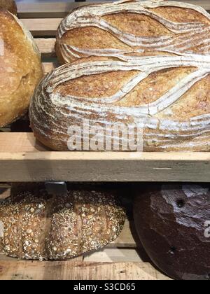 Pane fatto a mano sono visualizzati su uno scaffale in una sezione di panetteria negozio di alimentari. Foto Stock