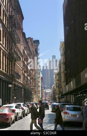 Vista tipica della strada del centro di Manhattan all'inizio della primavera, New York, New York, Stati Uniti. I pedoni attraversano la strada con le auto parcheggiate Foto Stock