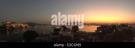Impostazione del sole che guarda sul lago di Pichola in Udaipur Rajasthan India Foto Stock