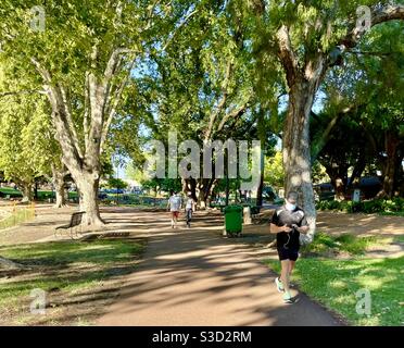 Persone che indossano maschere a piedi in Hyde Park durante Covid 19 Lockdown Perth Australia Occidentale Foto Stock