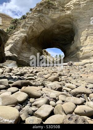 Buca sul muro lungo il Cooks Cove Walkway, Tolaga Bay Foto Stock