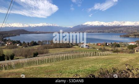 Vista panoramica sul Lago di Viverone nella regione della Biella Biellese Piemonte Piemonte Italia circondata da montagne innevate Foto Stock