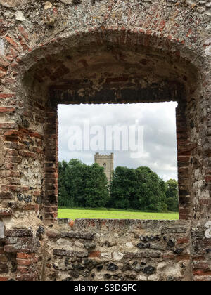 San Giacomo la Grande Chiesa, incorniciata attraverso l'ingresso al Castello Acre Priorato. Vicino a Swaffham, Norfolk, Inghilterra. Foto Stock