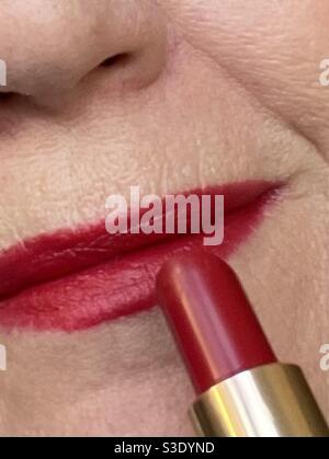 Donna che applica il rossetto rosso Foto Stock