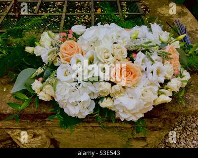 Pesca, rosa e bianco bouquet di fiori nuziali su parete di pietra Foto Stock