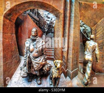 Particolare del fregio di bronzo alla base della statua, ‘il luogo d’incontro’, alla stazione ferroviaria internazionale di St Pancras, Londra. Creato dall'incredibile artista Paul Day. Foto Stock