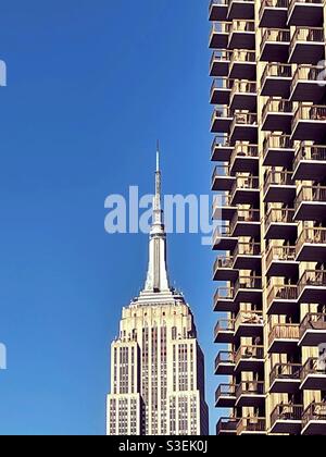 L'iconico edificio di stato dell'impero visto dal quartiere piano in ferro con balconi in primo piano, New York, USA Foto Stock