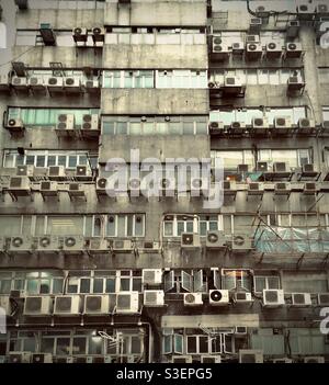 Edificio residenziale in cemento a Kowloon, Hong Kong, colorato con anni di polvere, inquinamento e pioggia Foto Stock