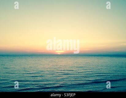 Tramonto su un mare blu nebby in Galles, Regno Unito - spazio copia, nessuna gente Foto Stock